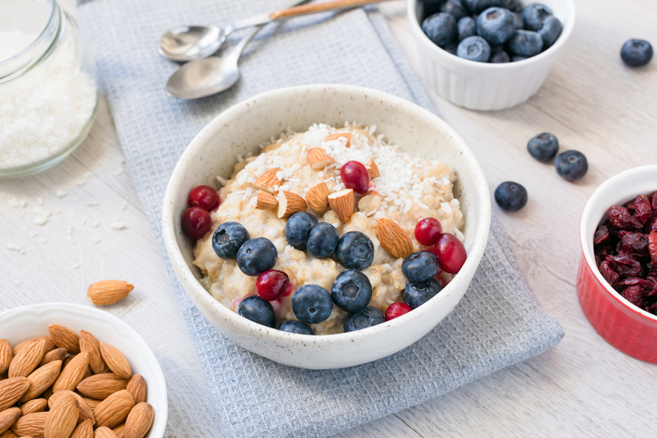 Oatmeal porridge bowl wtih blueberries, cranberries, almonds and coconut. Healthy breakfast, healthy eating concept